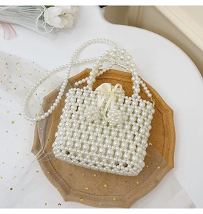 Detail of pearl woven handbag featuring silk drawstring liner and long pearl shoulder strap