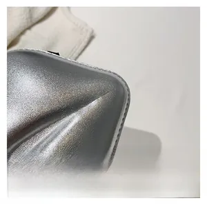 Détail macro d'une chaussure argentée à bout pointu montrant une texture métallique