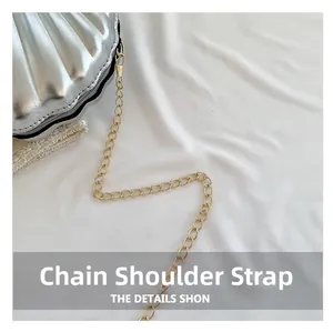 Detail of a silver shell bag showing metallic texture and gold chain strap