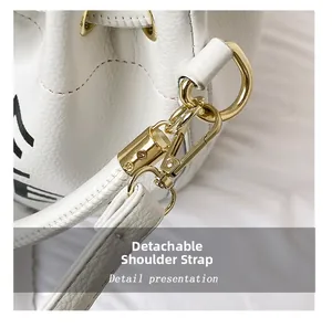 Detail of white lychee leather bag showing detachable gold spring hook and D-ring hardware