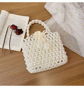 Detailed top view of a handmade pearl woven handbag with a satin drawstring lining