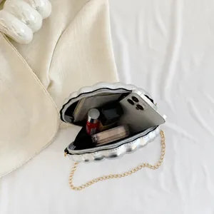 Internal storage view showing phone and lipstick inside silver shell crossbody bag