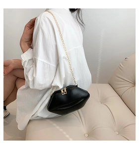 Détail du sac bandoulière créatif en cuir noir en forme de lèvres et chaîne dorée