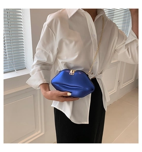 Détail du sac créatif en forme de lèvres bleu roi avec fini métallisé et chaîne dorée