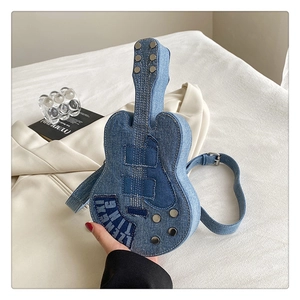 Gros plan du sac bandoulière en denim en forme de guitare avec rivets argentés