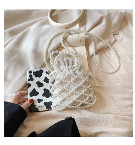 Detail of woven pearl handbag with drawstring inner pouch and long pearl strap