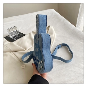 Détail du sac bandoulière en denim en forme de guitare avec rivets et motifs vintage
