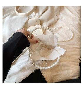 Detail of opening woven pearl bucket bag with linen fabric lining and large pearl handle