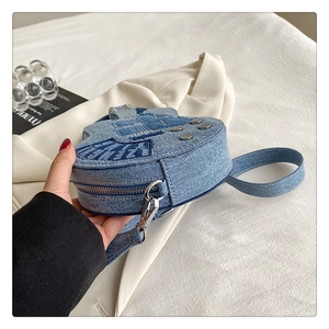 Vue détaillée du sac en denim en forme de guitare montrant le profil et la fermeture