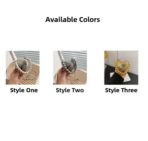 Detailed views of mini heart-shaped metal evening bags with pearl and bead handles