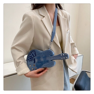 Détail du sac bandoulière en denim en forme de guitare avec rivets et broderies