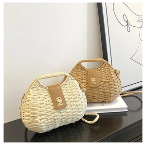 Dettaglio della borsa in paglia intrecciata con patta in pelle e chiusura girevole dorata