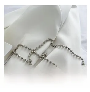 Detail view of the silver ball chain strap for the heart bag with metallic reflections