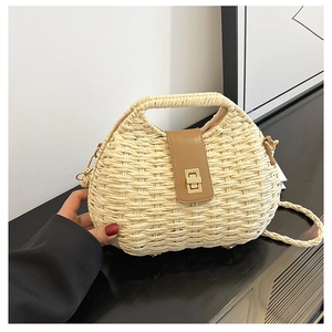 Dettaglio della borsa in paglia intrecciata con patta in pelle marrone e chiusura dorata