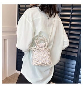 Detailed view of handmade pearl woven bucket bag with long strap and inner silk drawstring
