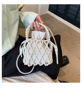 Detail of handmade pearl woven bag with cream drawstring liner and elegant pearl chain strap