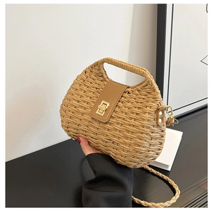 Dettaglio borsa in paglia intrecciata con patta in pelle marrone e chiusura a girello