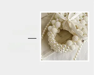 Detail magnification of cream white pearl woven handbag with elegant satin ribbon bow