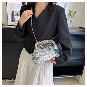 Detail of silver sequin evening bag with gold metal frame and spherical clasp