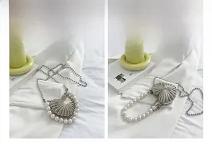 Macro detail of silver heart metal bag with pearl trim and stylish bead chain