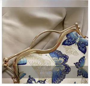Macro detail of luxury blue butterfly embroidery and ornate gold hollow metal handle
