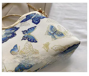 Close-up of vintage butterfly print on textured fabric with elegant gold metal handle