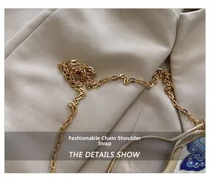 Detail of golden metal chain strap and blue butterfly embroidery on vintage handbag