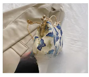 Close-up of vintage butterfly embroidery and gold metal clasp on the handbag side