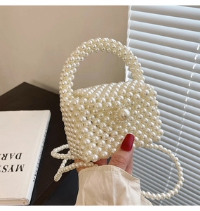 Detail shot of the woven pearl handbag texture with elegant beaded handle and long strap