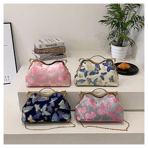 Macro detail of four vintage silk bags with intricate floral and butterfly embroidery