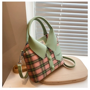 Detail van geruite handtas met creatief overhemdkraagontwerp in roze en groen ruitpatroon