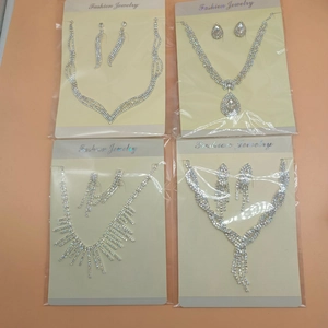 Dettaglio di parure con collana e orecchini in strass argento in vari stili a strati