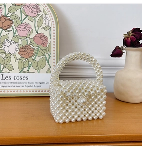 Detail of handcrafted white pearl woven handbag with elegant large pearl clasp and handle