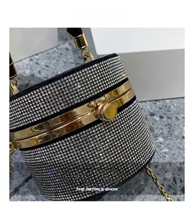 Close-up of sparkling rhinestone evening bag with gold metal spherical lock and chain