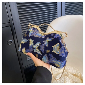 Close-up of vintage dark blue handbag featuring intricate gold butterfly embroidery