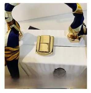 Detail of gold metal lock and silk scarf wrapped handle on white illustrated handbag