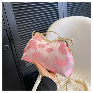 Detail of pink floral embroidery and golden metal frame on elegant silk evening bag