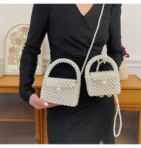 Detail of white handmade pearl woven handbag and mini pouch with elegant chain strap