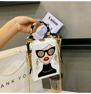 Detail of white box bag with fashion illustration, silk handle, and metal chain strap