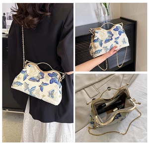 Detail of vintage evening bag featuring blue butterfly embroidery and golden clasp closure
