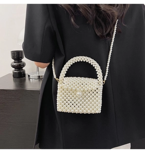 Detailed view of handmade pearl woven mini bag against black blazer for elegant contrast