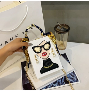 Detail of white box bag with fashion portrait print and scarf wrapped handle