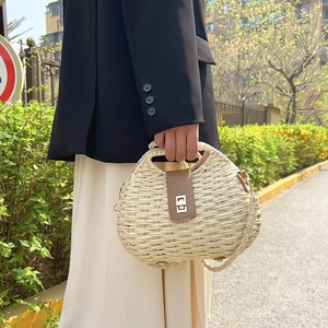 Borsa a cesto in paglia intrecciata beige con chiusura in pelle e tracolla regolabile