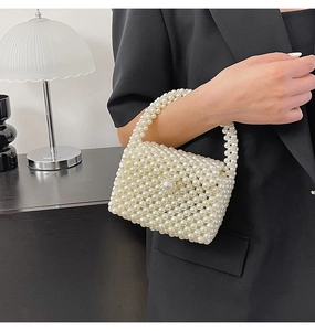 Close-up of handmade white pearl woven handbag with elegant top handle and flap