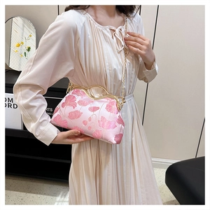 Close-up of pink floral clutch with vintage gold clasp and delicate chain strap