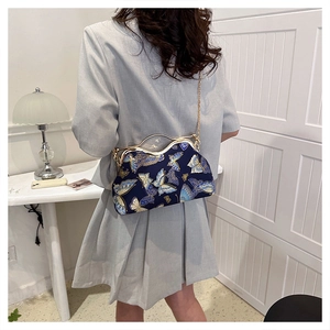 Detail of vintage navy blue evening bag with gold butterfly embroidery and chain strap