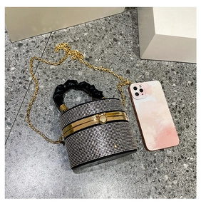 Detailed view of rhinestone evening bag with gold chain and phone for scale reference