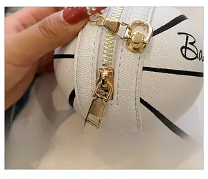 Close-up of golden metal zipper and pebble grain leather on white basketball coin purse