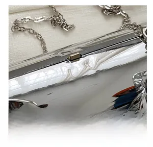 Close-up of a metallic silver cylinder bag with a golden clasp and thick chain strap