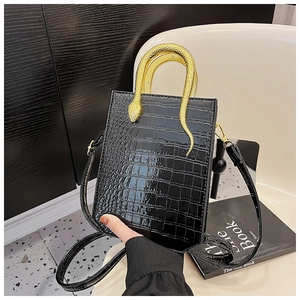 Detailed view of black crocodile pattern tote bag with gold snake-shaped metal handle
